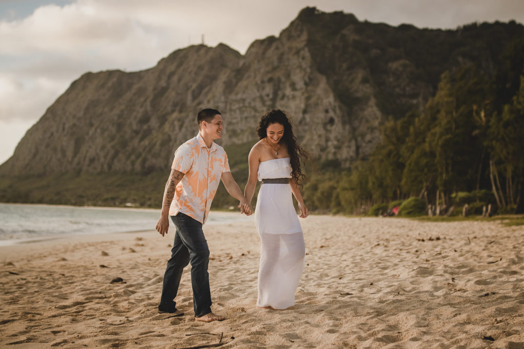 Couple walking along a tropical beach in Hawaii.
