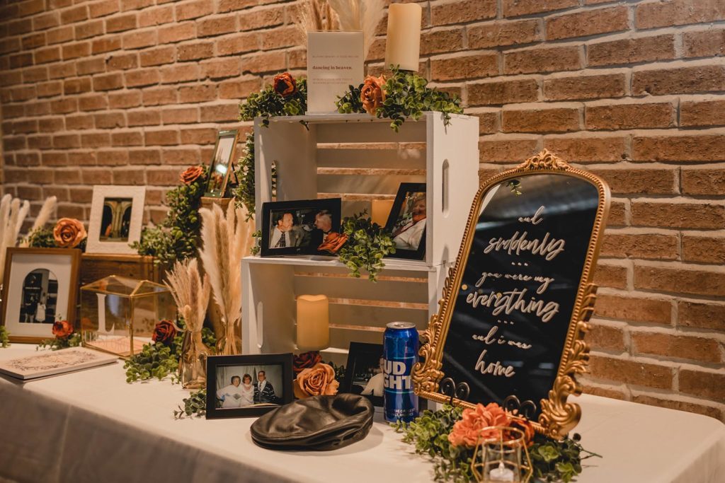 "In loving memory" table at wedding reception featuring photos of lost loved ones
