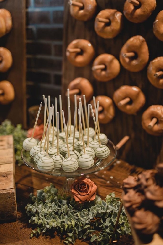 Desert bar at wedding reception with cake pops and glazed donuts