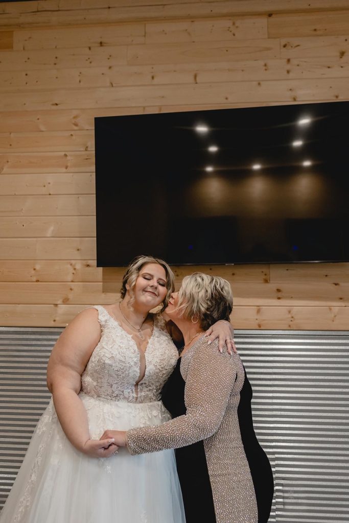 Mother of bride and bride embracing after first look
