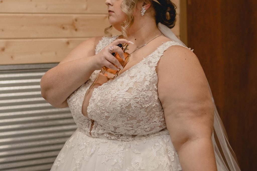 Bride applying perfume before her wedding ceremony
