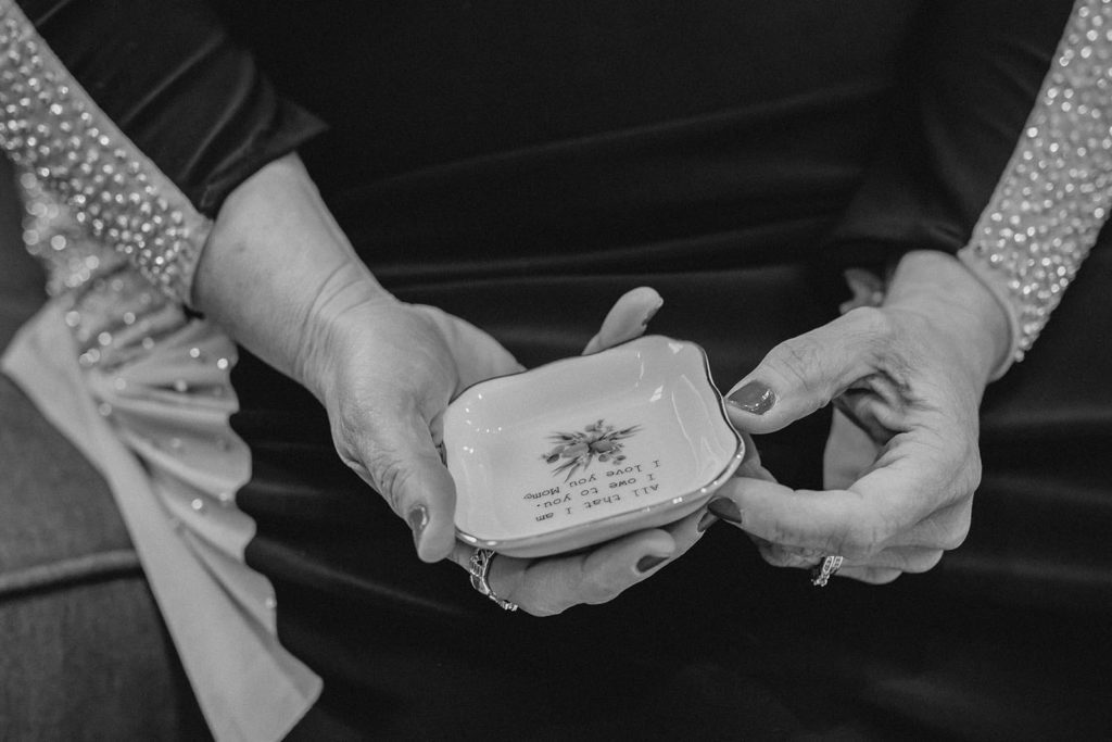 Mother of the bride holding a small dish gifted to her by her daughter