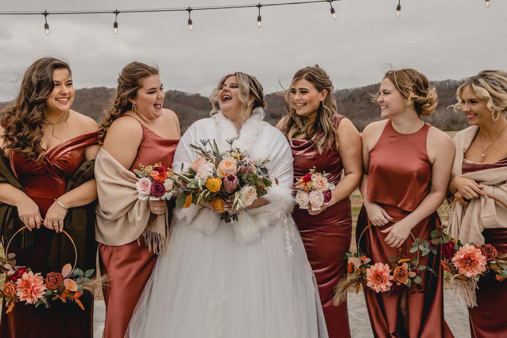 Bride and her bridesmaids laughing and smiling in a line