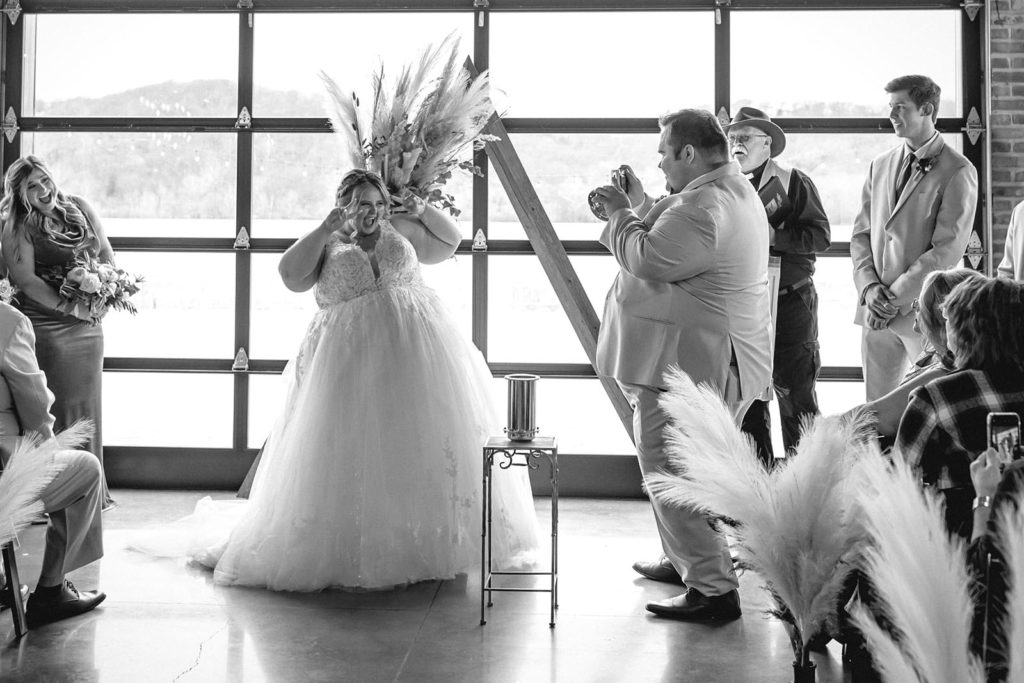 Groom taking polaroid photo of bride during wedding ceremony