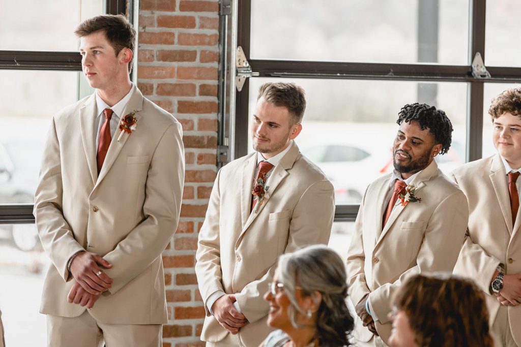 Groomsmen look on during wedding ceremony