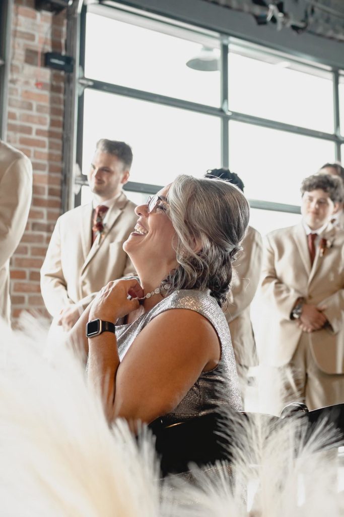 Mother of the groom laughing during wedding ceremony