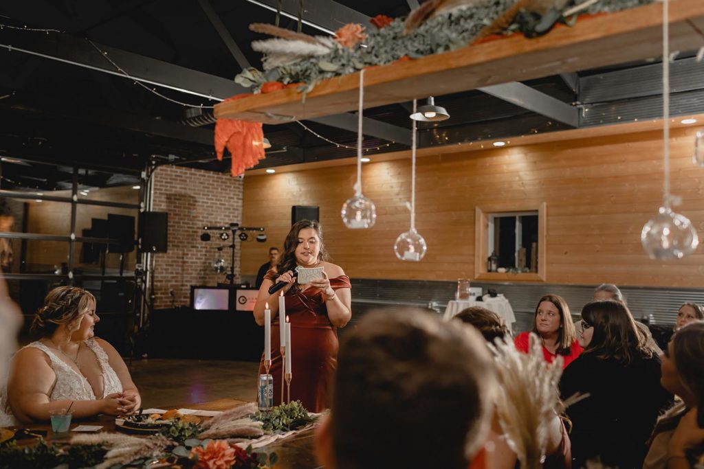Maid of honor toasting with bride during wedding reception speech