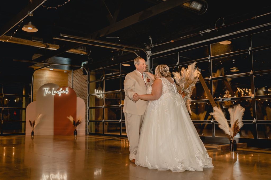 Bride and her father dancing together at wedding reception 