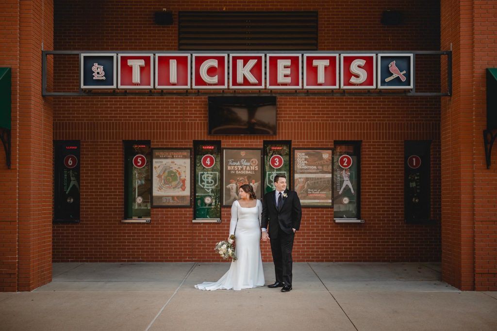 Bride and groom at busch stadium ticket window on wedding day.