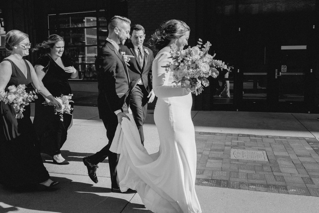 Black and white photo of bride walking on paved sidewalk in St. Louis