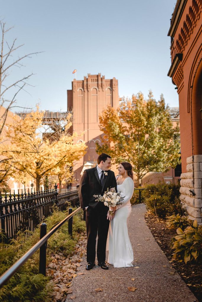 Bride and groom posing at Anheiser Busch Brewery with fall colors