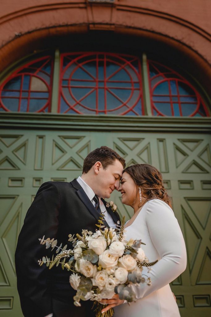 Bride and groom posing at Anheiser Busch Brewery with large green door