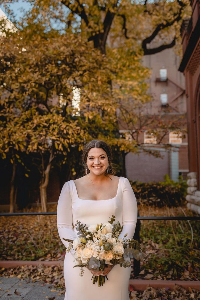 Bride posing at Anheiser Busch Brewery infront of fall trees