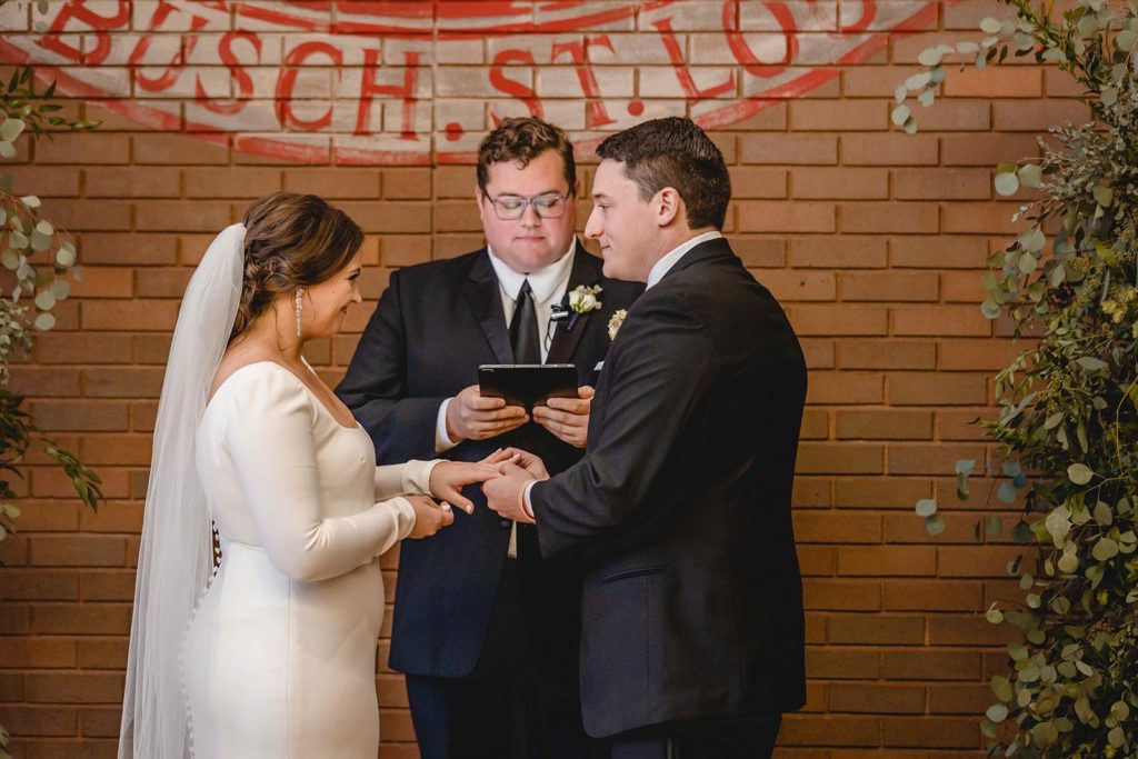 Wedding ceremony at Anheuser Busch beer garden exchanging rings