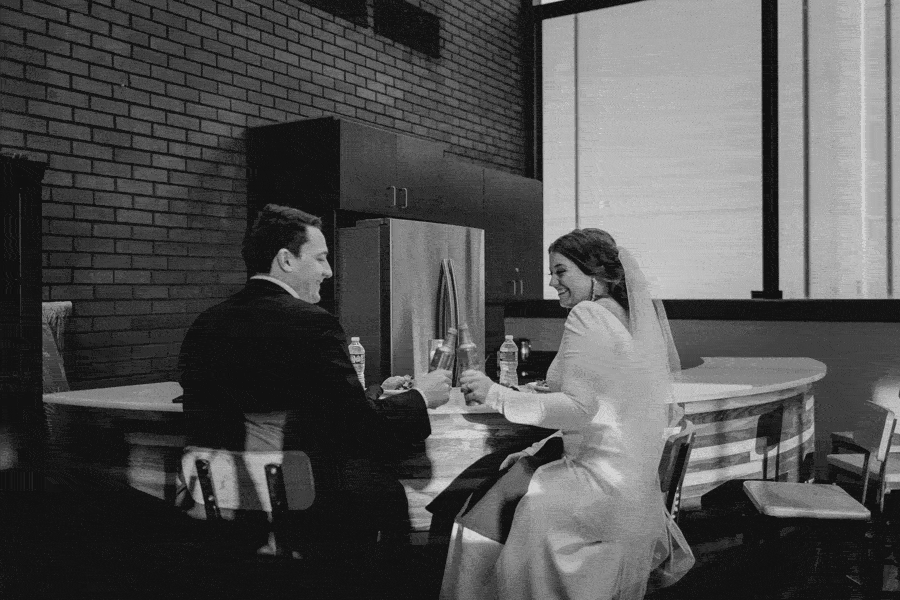 Bride and groom toasting at private dinner black and white
