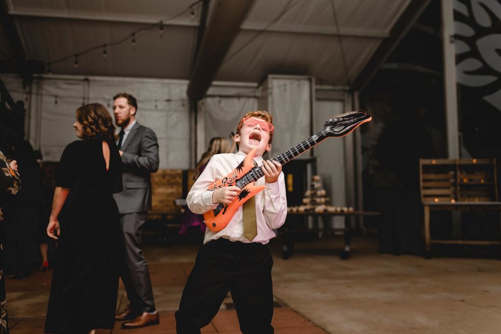 Guest dancing at Anheuser Busch Brewery wedding with inflatible instruments