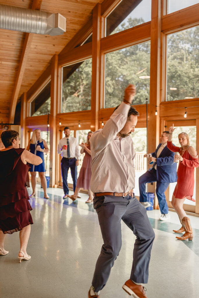 wedding guests dance the in the indoor late afternoon dance floor