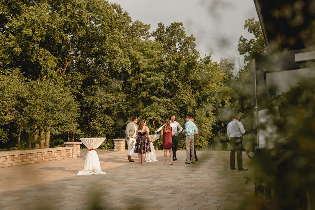 wedding guests mingle on the outdoor patio