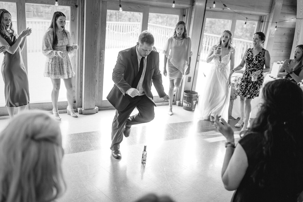 father of the groom does a jig around a bottle of jameson whisky on the ground