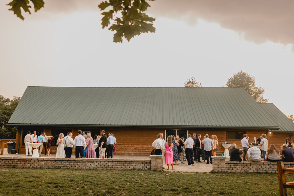 wide shot of Quail Ridge Lodge's outdoor patio filled with wedding guests mingling