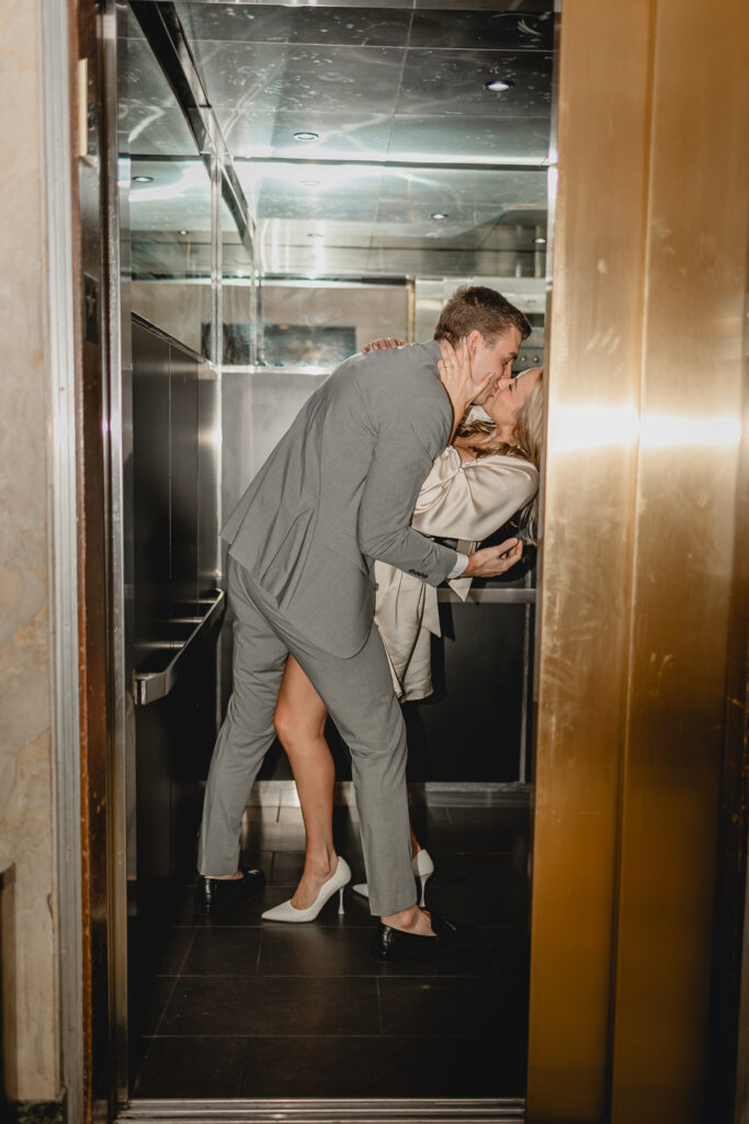 couple dipping into a kiss inside a mirrored elevator as the door begins to close 
