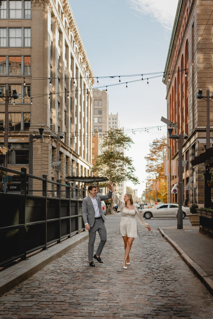 young couple dance along a historic downtown St. Louis cobblestone street