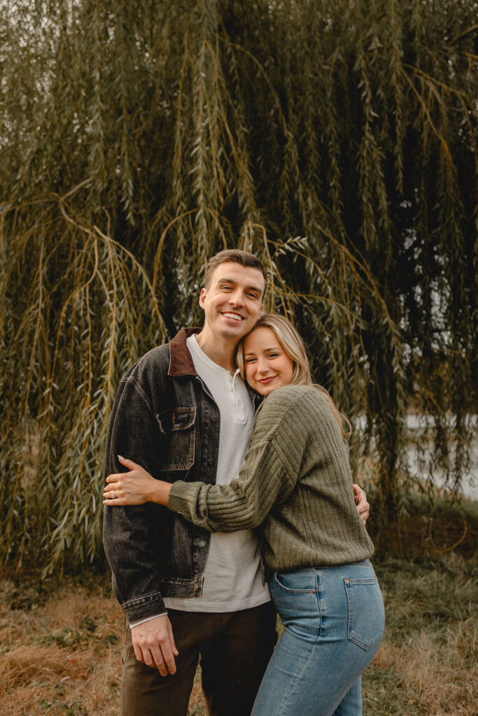 woman in a cozy green sweater and jeans hugs her boyfriend in a white t and black denim jacket outsider