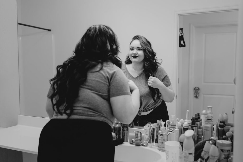 bride looking in the mirror at her reflection to see new wedding makeup