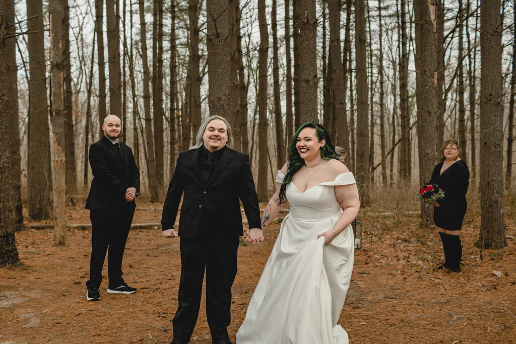 bride and groom beam as they hold hands and face their guests after being announced married