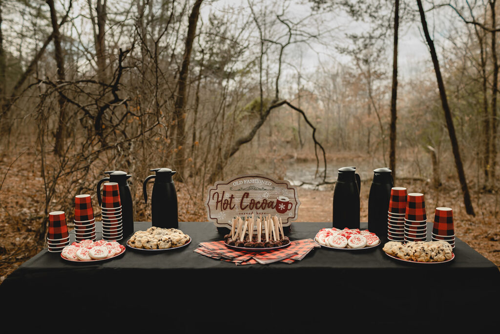 a homemade hot chocolate bar table in  the middle of the woods