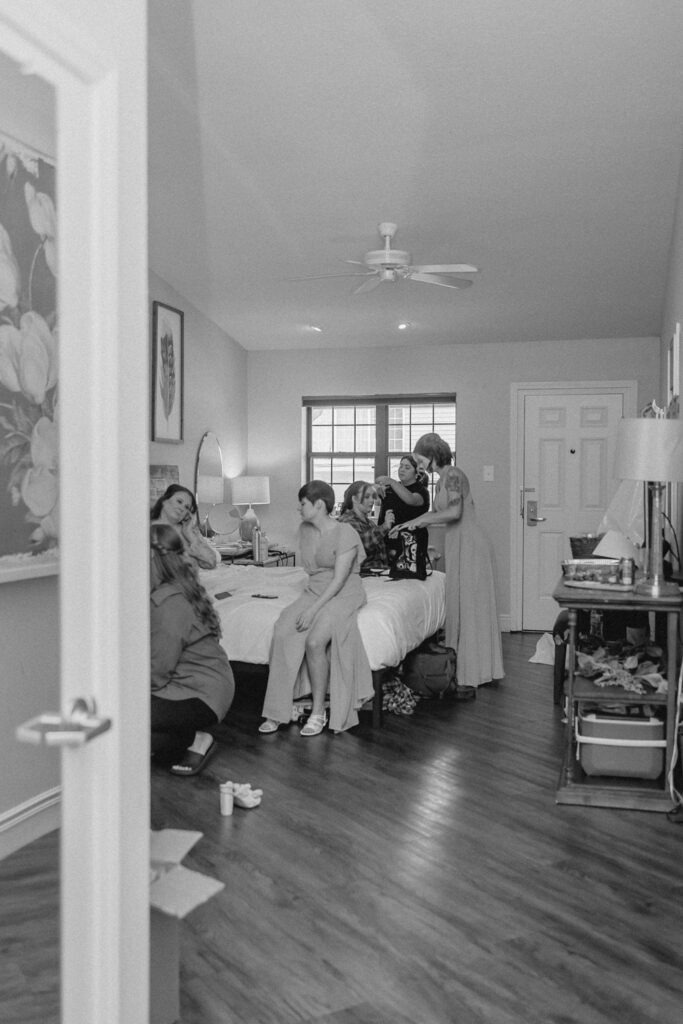 Bridesmaid getting ready before wedding ceremony in a hotel room.