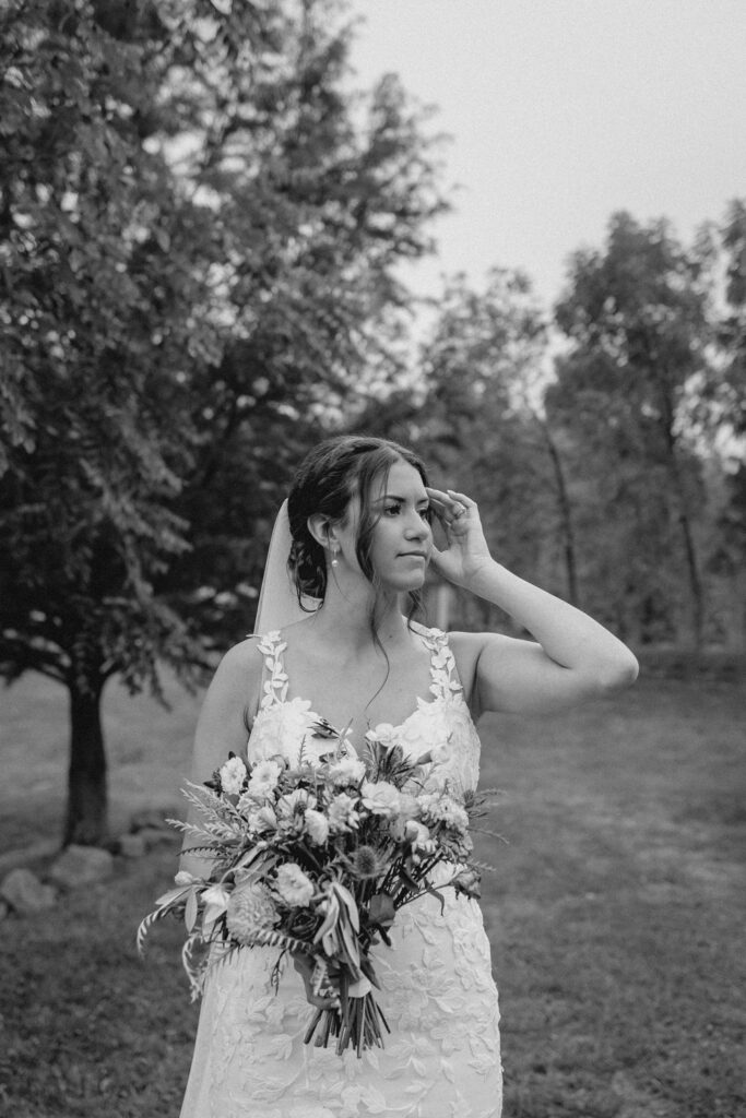 Face of shot of bride holding bouquet of flower and looking off into the distance.