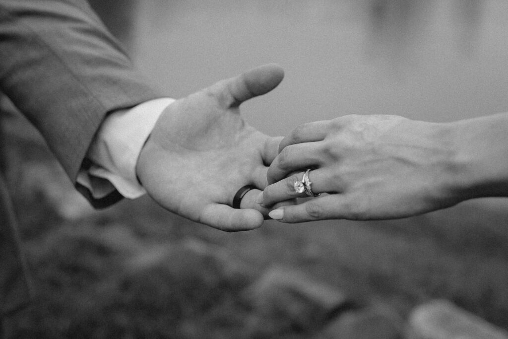 Close up shot of bride and grooms hands with wedding ring showing.