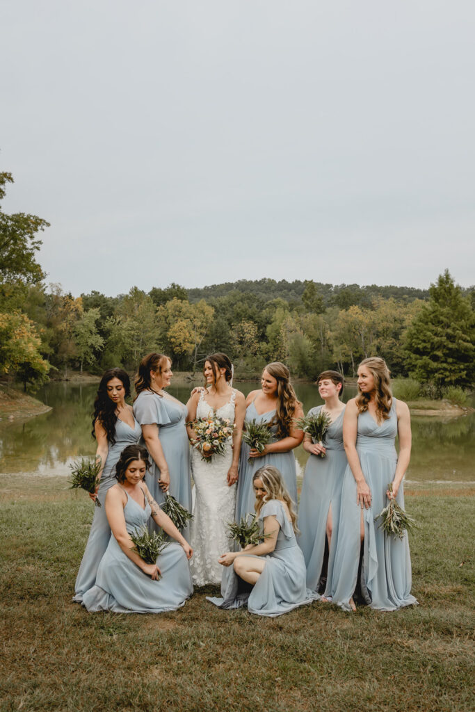 Bridal party posing at lost hill lake at waterside.