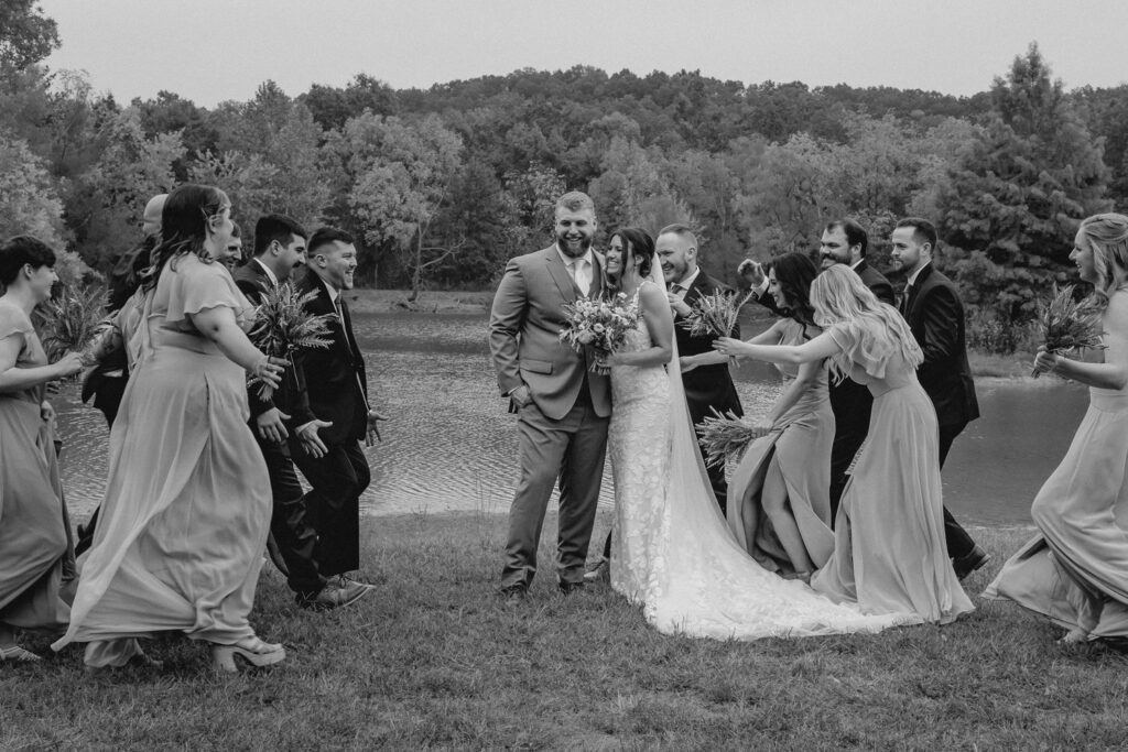 Wedding party laughing with bride and groom.