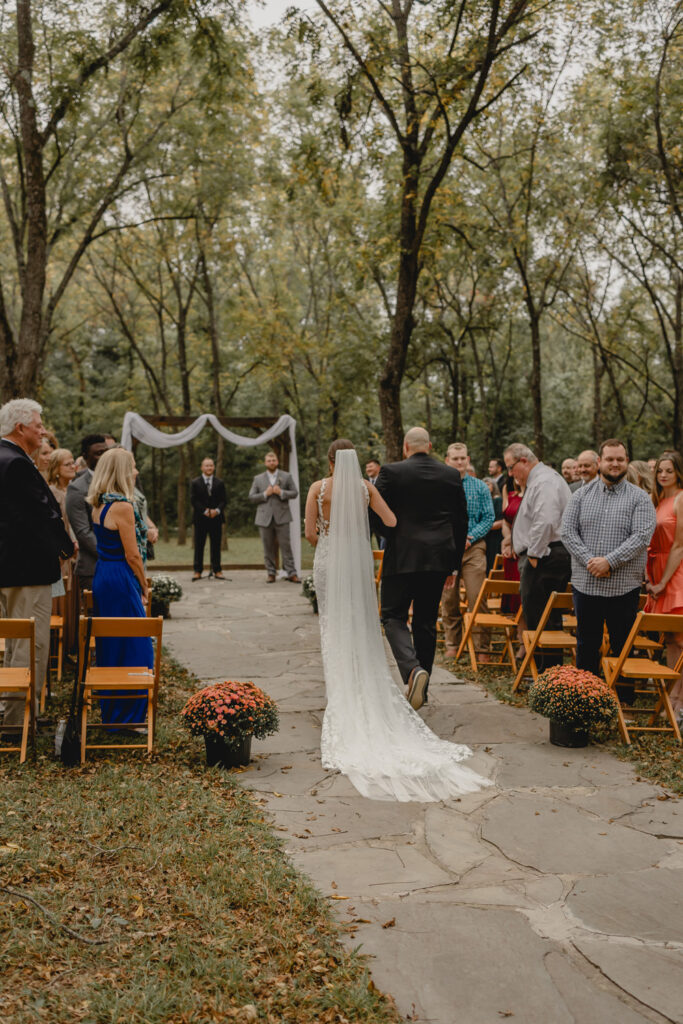 Bride and her brother walk down aisle at outdoor wedding in walnut grove