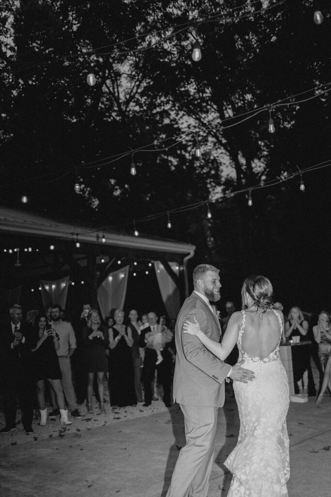 Bride and groom share their first dance in front of guests