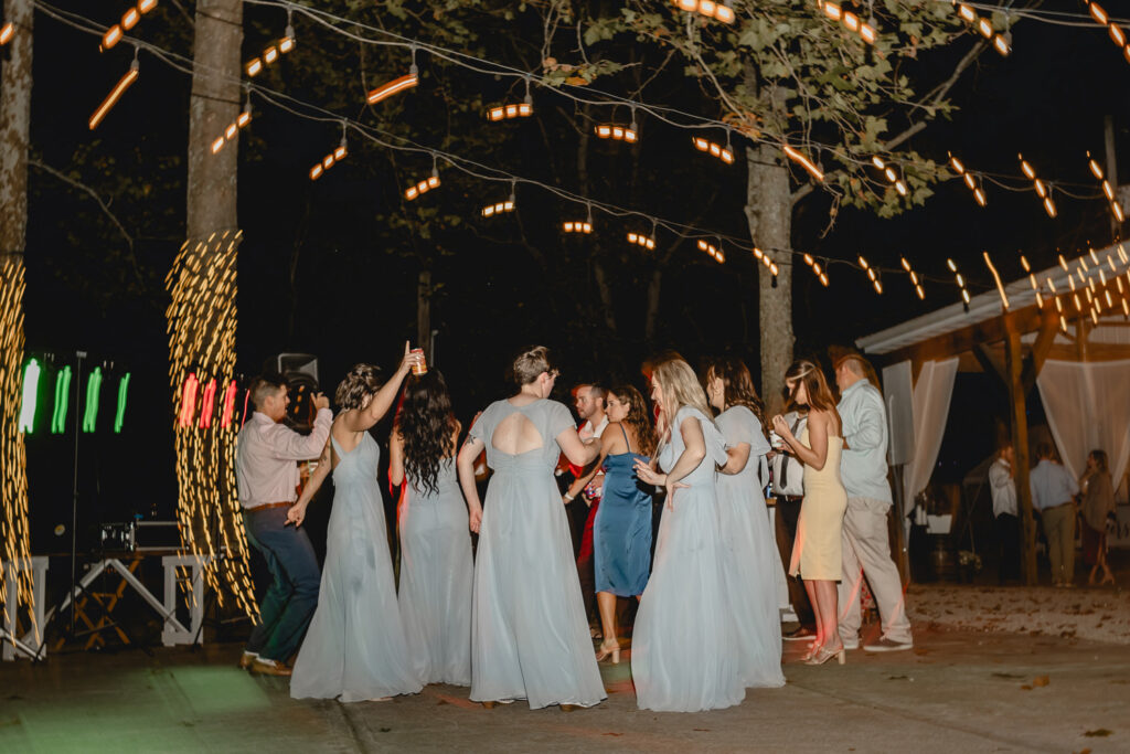 Bridal party dancing at outdoor wedding reception at lost hill lake.